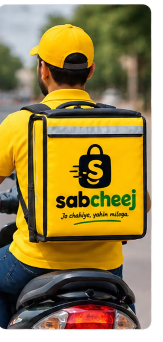 A sabCheej delivery partner on a scooter, carrying a branded delivery box